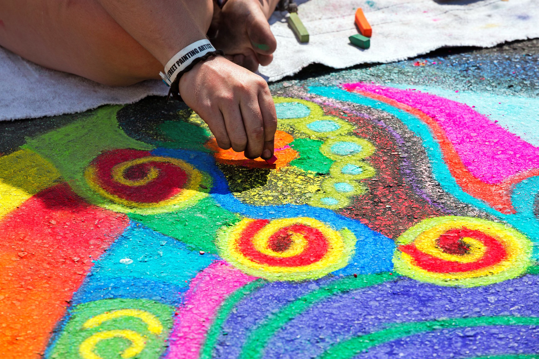 Artist doing a Bright chalk street painting